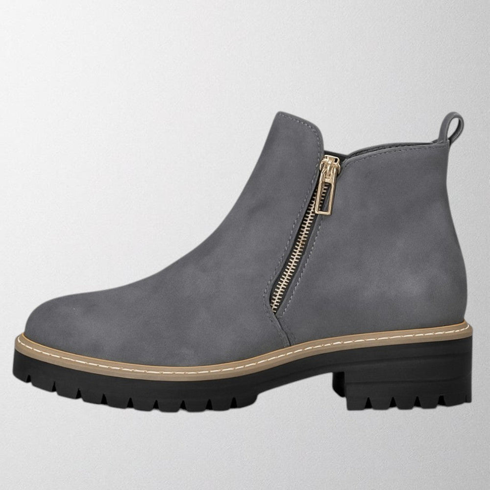 Black ankle boots for women featuring a stylish gold zip, chunky lug sole, and soft suede upper for a comfortable fit. 1