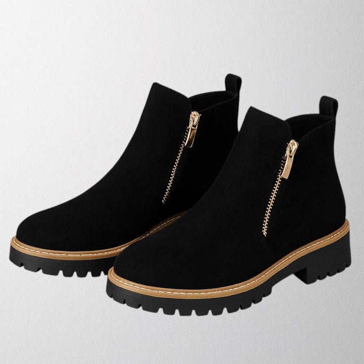 Black ankle boots for women featuring a stylish gold zip, chunky lug sole, and soft suede upper for a comfortable fit. 6