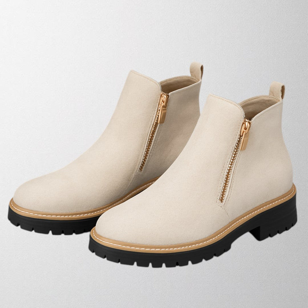 Black ankle boots for women featuring a stylish gold zip, chunky lug sole, and soft suede upper for a comfortable fit. 8