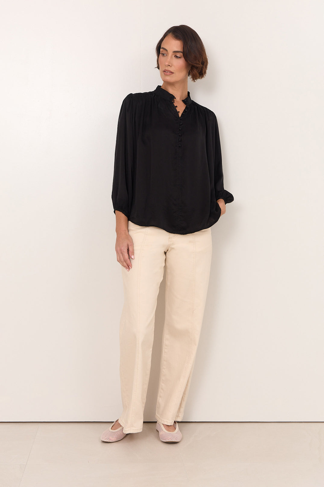 Black Cupro women's top featuring a stylish button-down front and 3/4 sleeves, designed with an elegant fluid drape for a chic and sophisticated 1