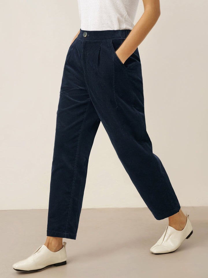 Cotton tapered pants in charcoal black with an elastic waist, designed for a tailored fit for men. 0