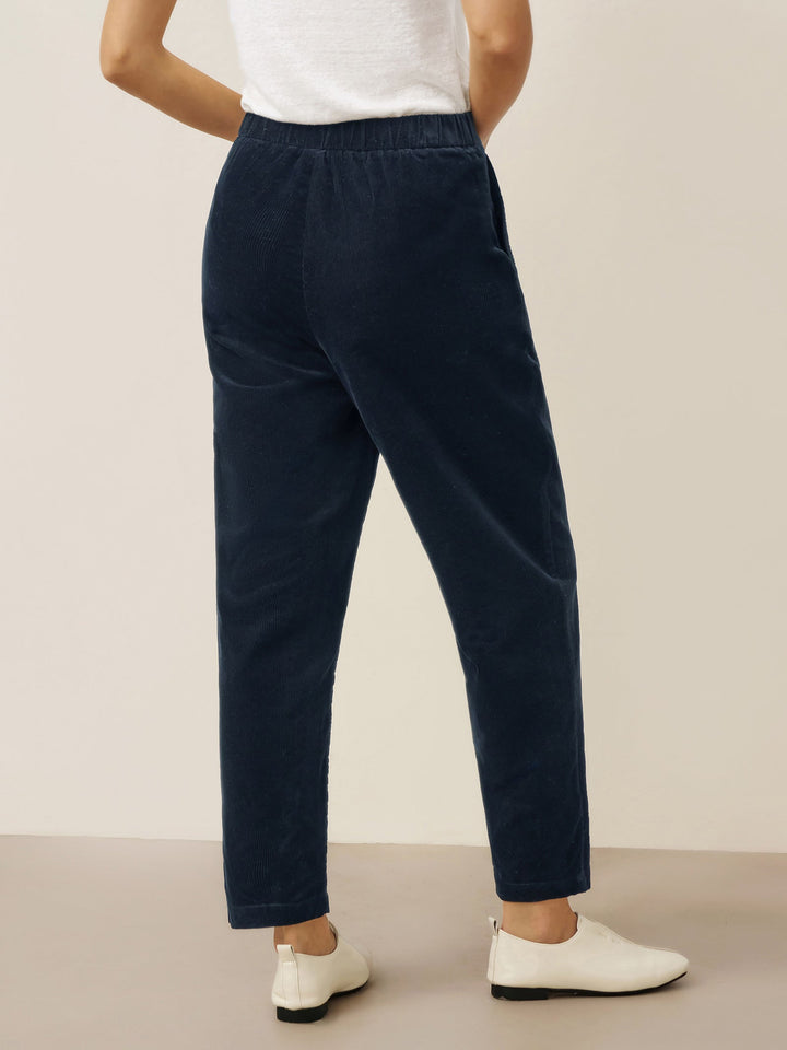 Cotton tapered pants in charcoal black with an elastic waist, designed for a tailored fit for men. 4