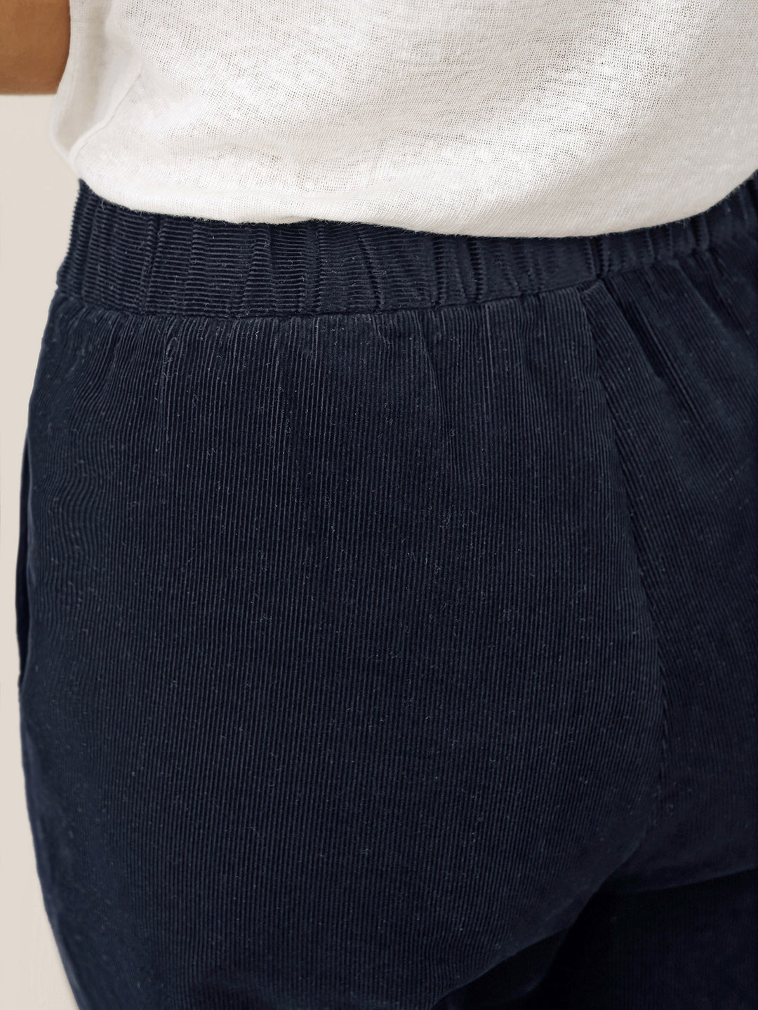 Cotton tapered pants in charcoal black with an elastic waist, designed for a tailored fit for men. 7