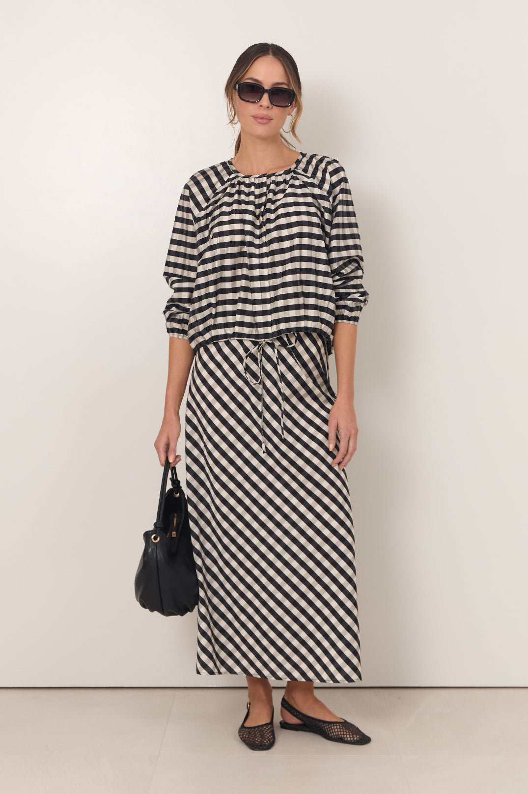 Gingham maxi skirt featuring an adjustable waistband and bias-cut design in black and white, perfect for stylish women's outfits. 1
