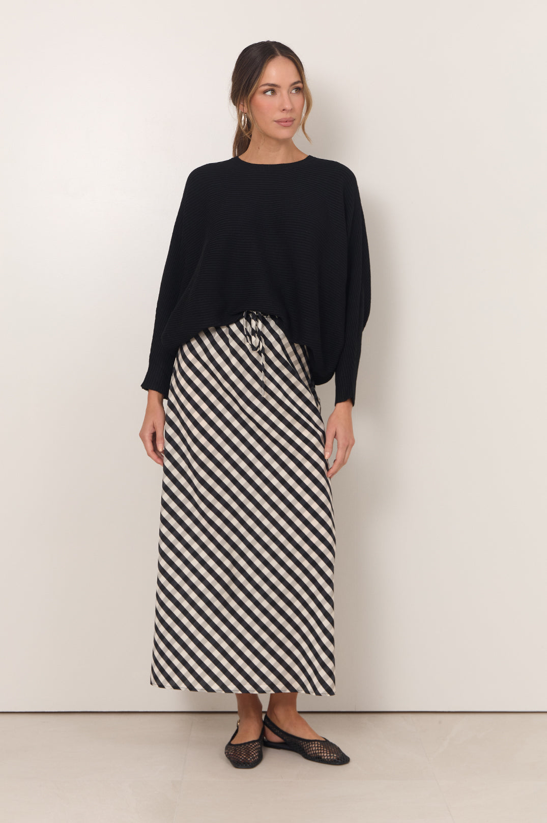 Gingham maxi skirt featuring an adjustable waistband and bias-cut design in black and white, perfect for stylish women's outfits. 2