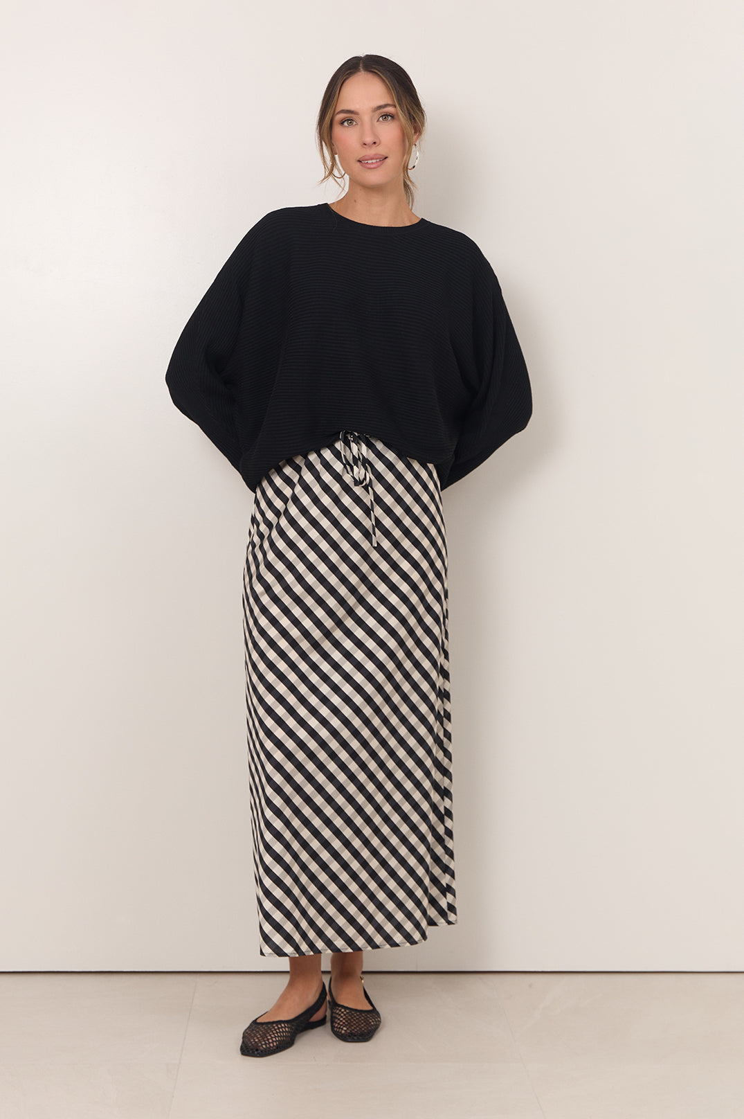 Gingham maxi skirt featuring an adjustable waistband and bias-cut design in black and white, perfect for stylish women's outfits. 4