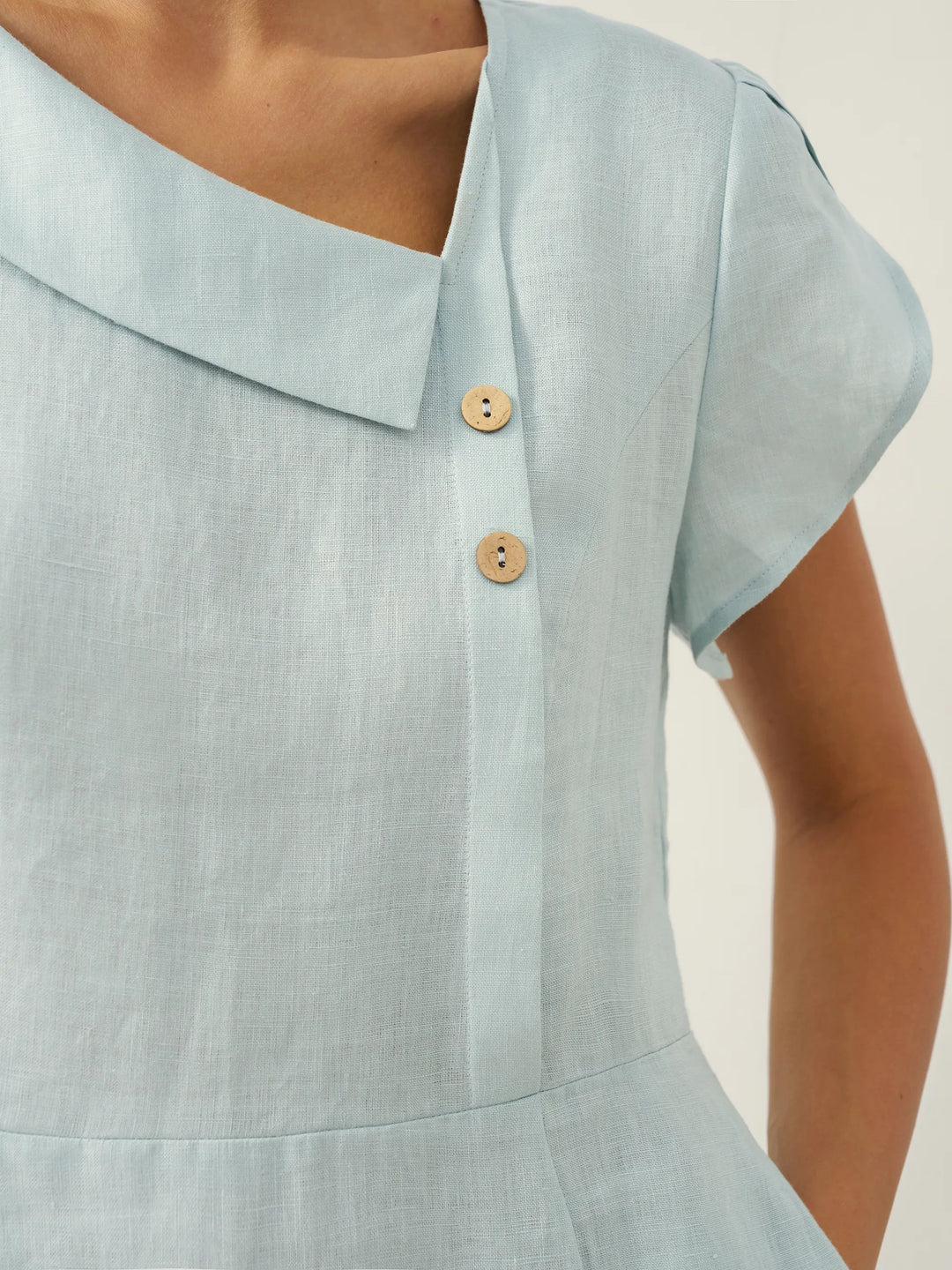 Linen midi dress featuring asymmetric button detail and cap sleeves, designed for a tailored fit, perfect for wedding guests and summer events. 4