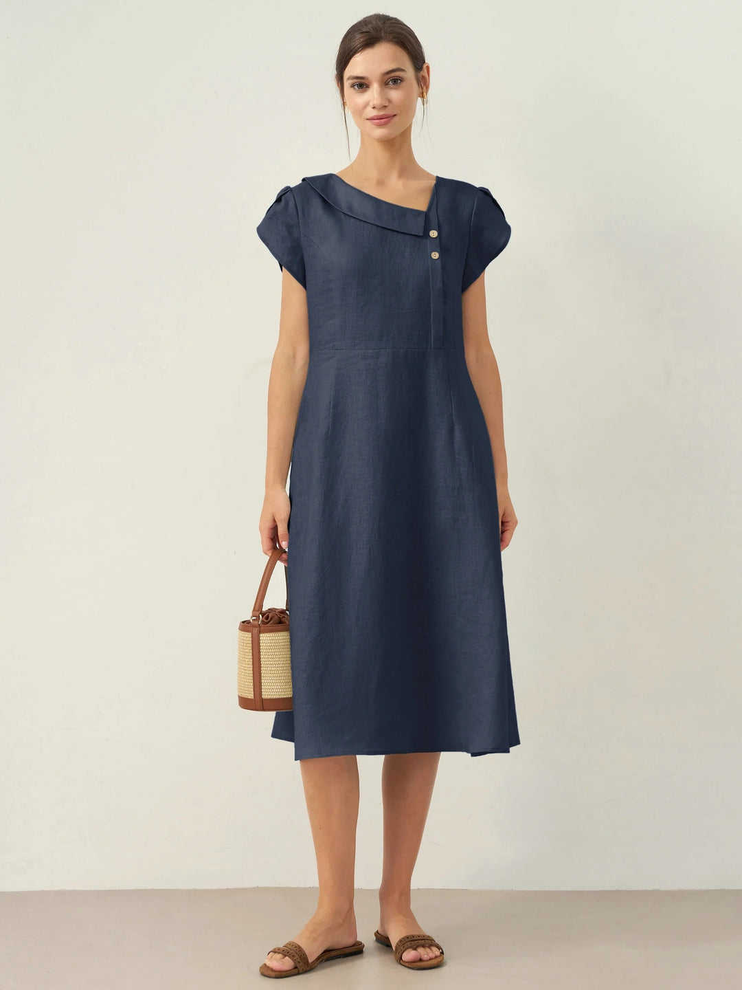 Linen midi dress featuring asymmetric button detail and cap sleeves, designed for a tailored fit, perfect for wedding guests and summer events. 8