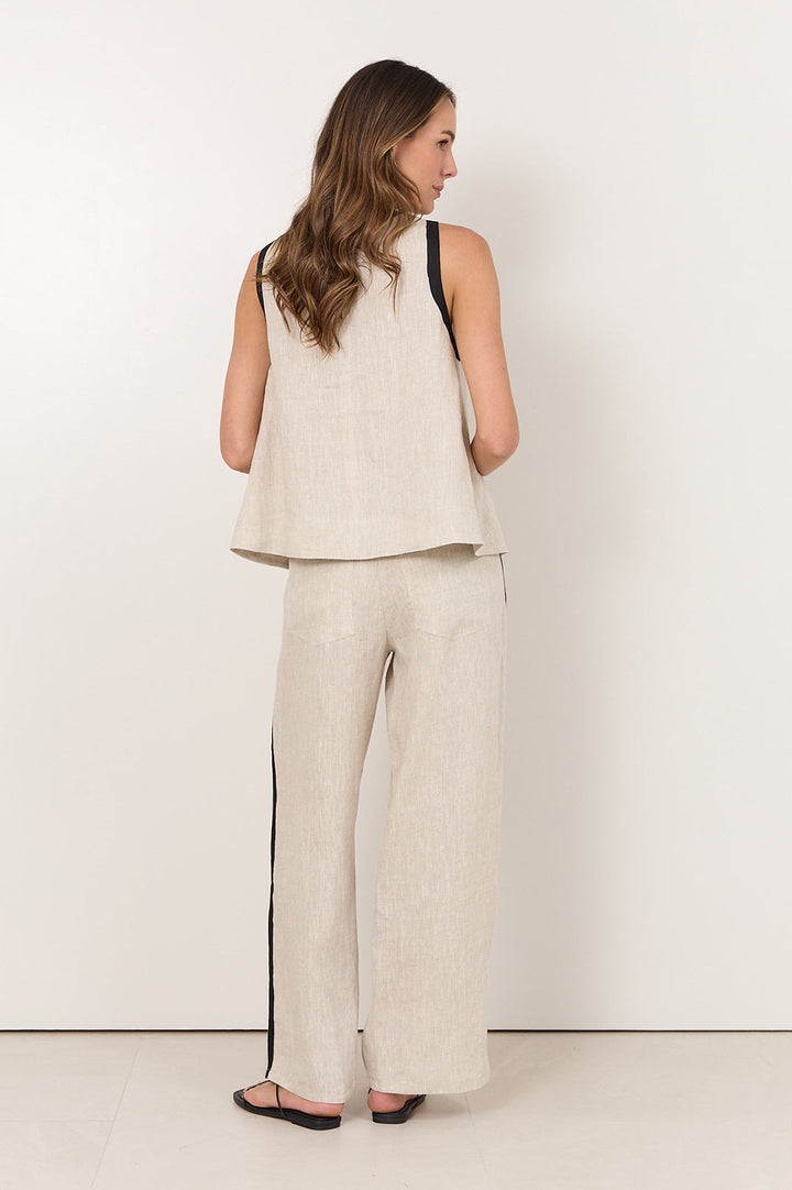 Linen pants for women featuring an elastic waistband, side pockets, and a natural straight-leg design accented with black trim. 4