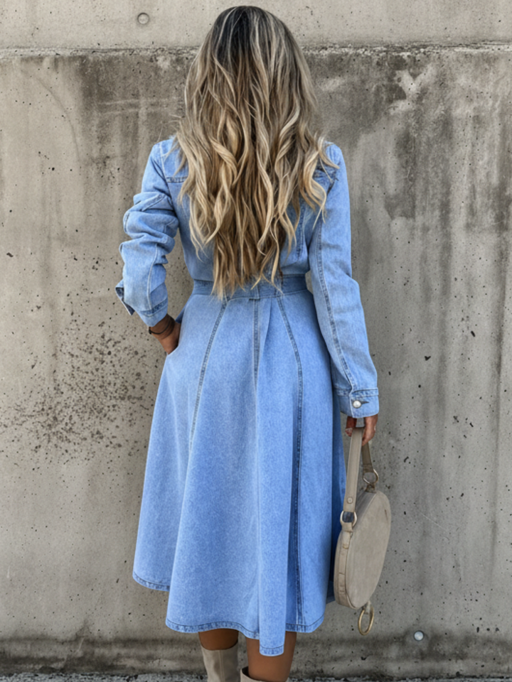 Long chambray dress for women featuring an A-line silhouette, waist belt, and long sleeves, designed in a stylish denim-inspired style. 1