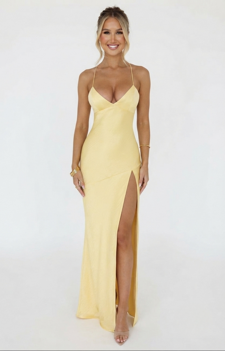 Satin halter neck maxi dress in butter yellow featuring a thigh-high slit, perfect for elegant evening events and summer occasions. 0