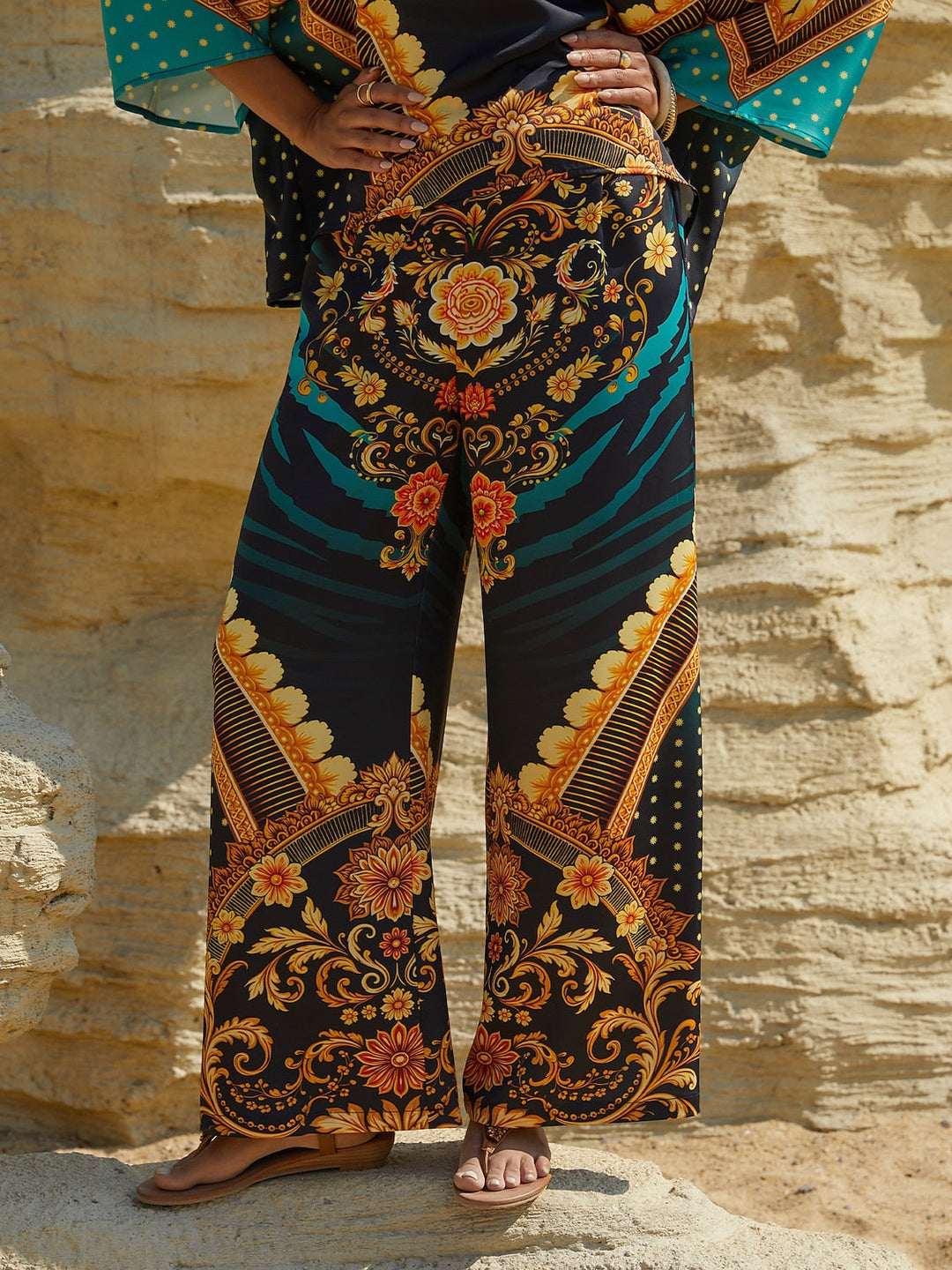 Silky satin women's pants in Mediterranean blue featuring a gold-chain print and an elastic waistband, designed in a stylish straight-leg cut. 10