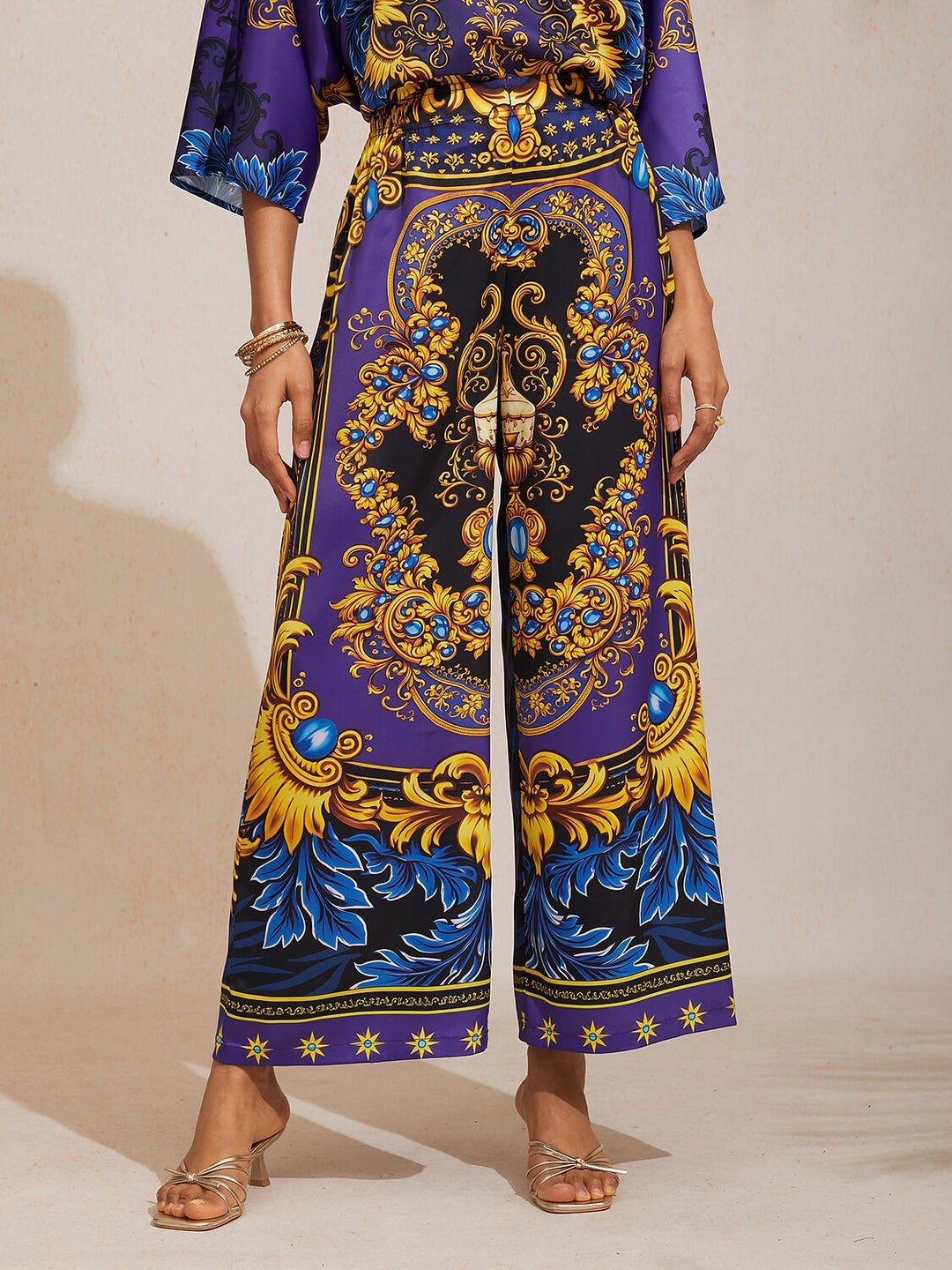 Silky satin women's pants in Mediterranean blue featuring a gold-chain print and an elastic waistband, designed in a stylish straight-leg cut. 13