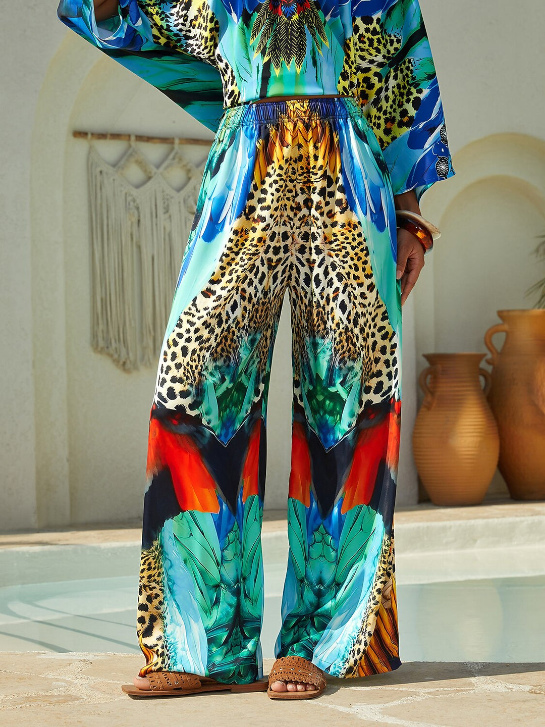 Silky satin women's pants in Mediterranean blue featuring a gold-chain print and an elastic waistband, designed in a stylish straight-leg cut. 16
