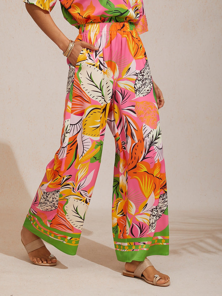 Silky satin wide leg pants featuring an elastic waist and vibrant tropical print, designed for a flowy relaxed fit for women. 0