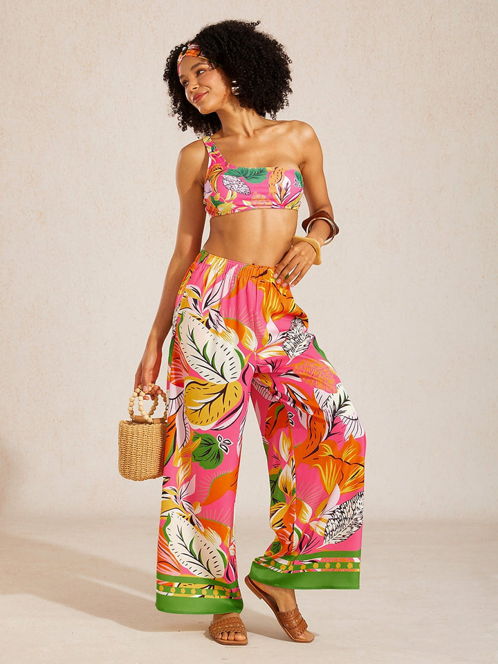 Silky satin wide leg pants featuring an elastic waist and vibrant tropical print, designed for a flowy relaxed fit for women. 1
