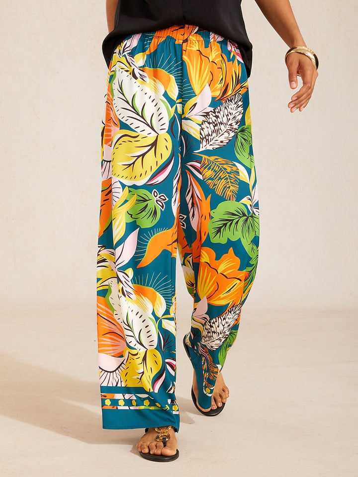 Silky satin wide leg pants featuring an elastic waist and vibrant tropical print, designed for a flowy relaxed fit for women. 16