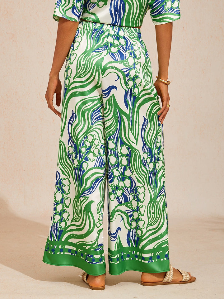 Silky satin wide leg pants featuring an elastic waist and vibrant tropical print, designed for a flowy relaxed fit for women. 6