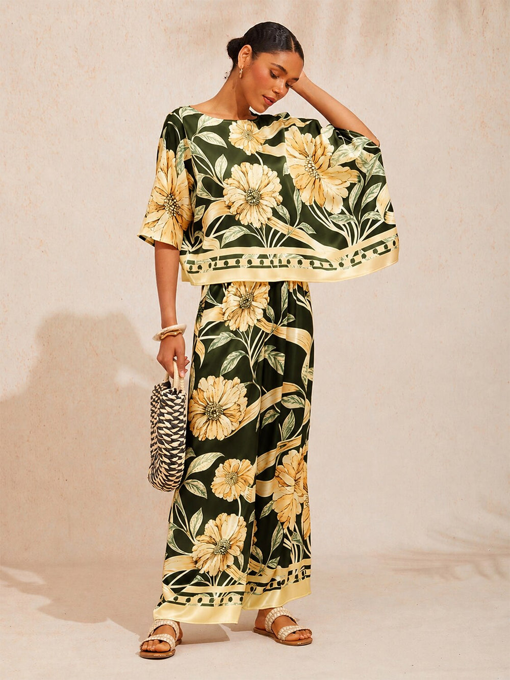 Wide leg pants for women made of silky satin featuring an elastic waist and a floral design in cream and yellow. 1