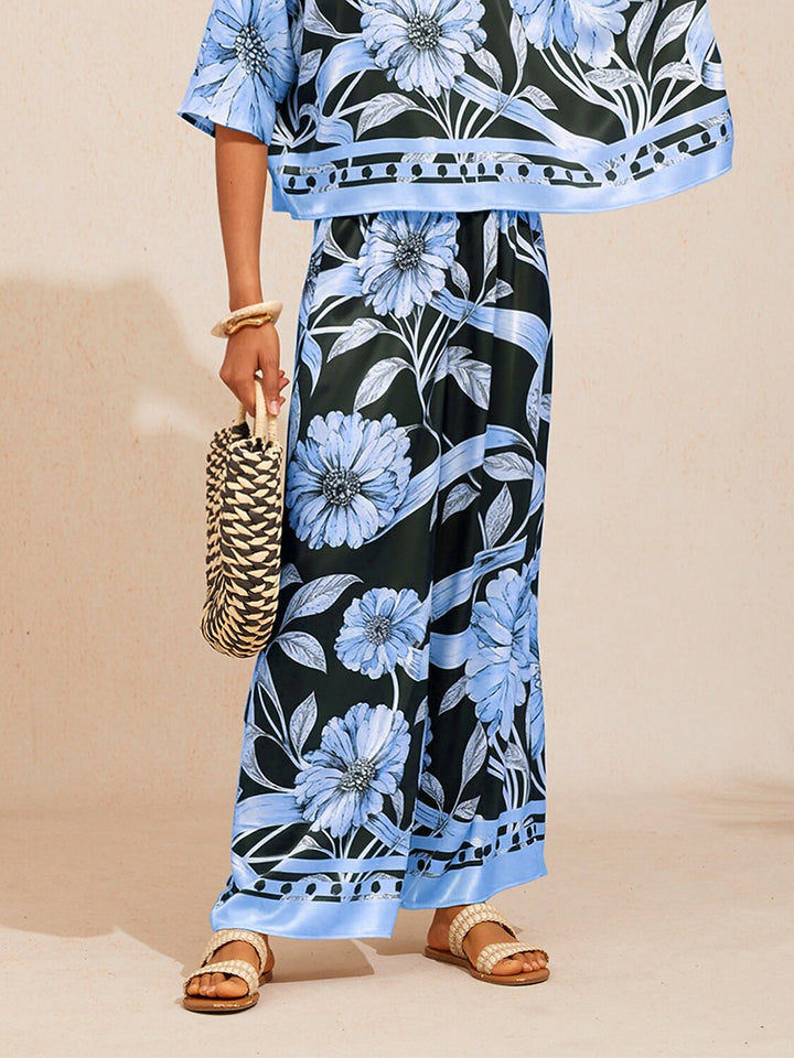 Wide leg pants for women made of silky satin featuring an elastic waist and a floral design in cream and yellow. 16