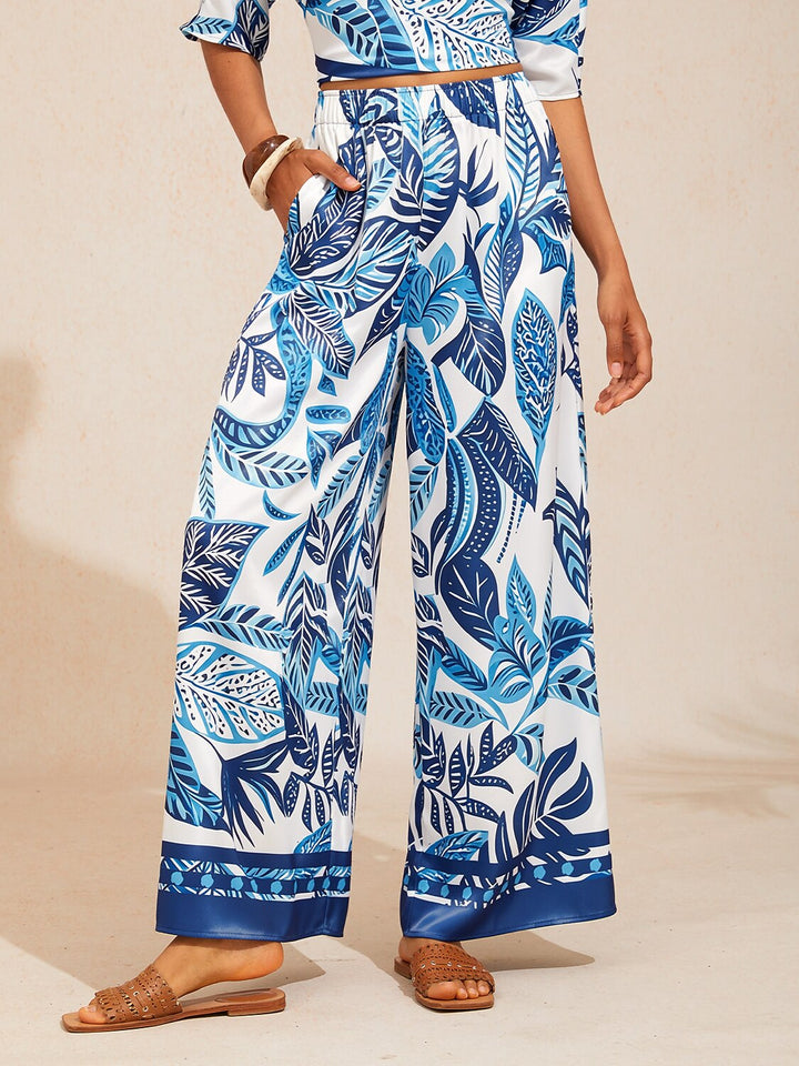 Wide leg pants for women made of silky satin featuring an elastic waist and a floral design in cream and yellow. 17