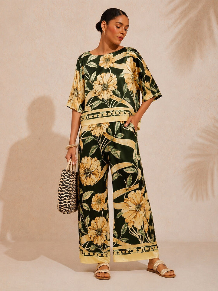 Wide leg pants for women made of silky satin featuring an elastic waist and a floral design in cream and yellow. 3