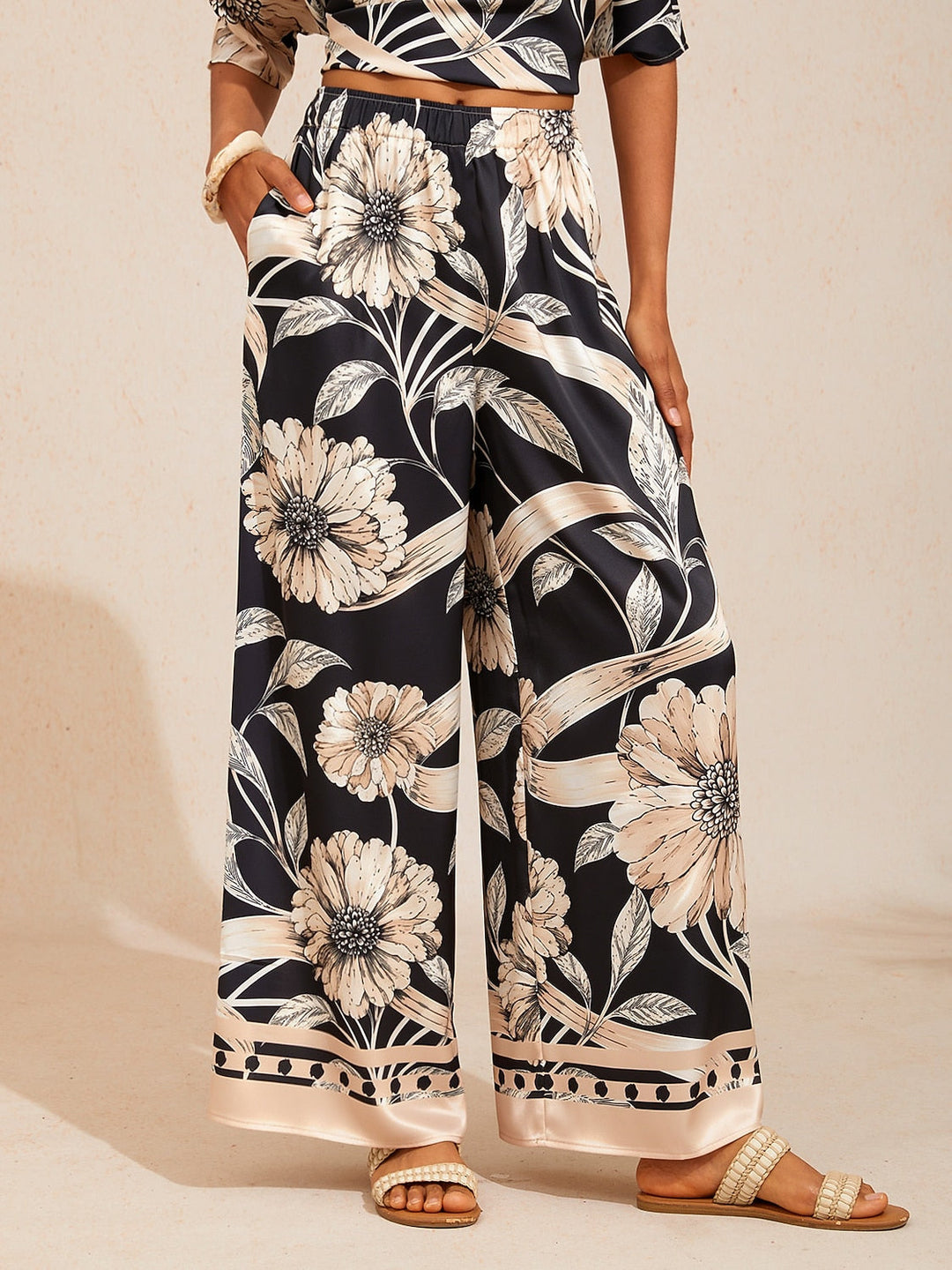 Wide leg pants for women made of silky satin featuring an elastic waist and a floral design in cream and yellow. 4