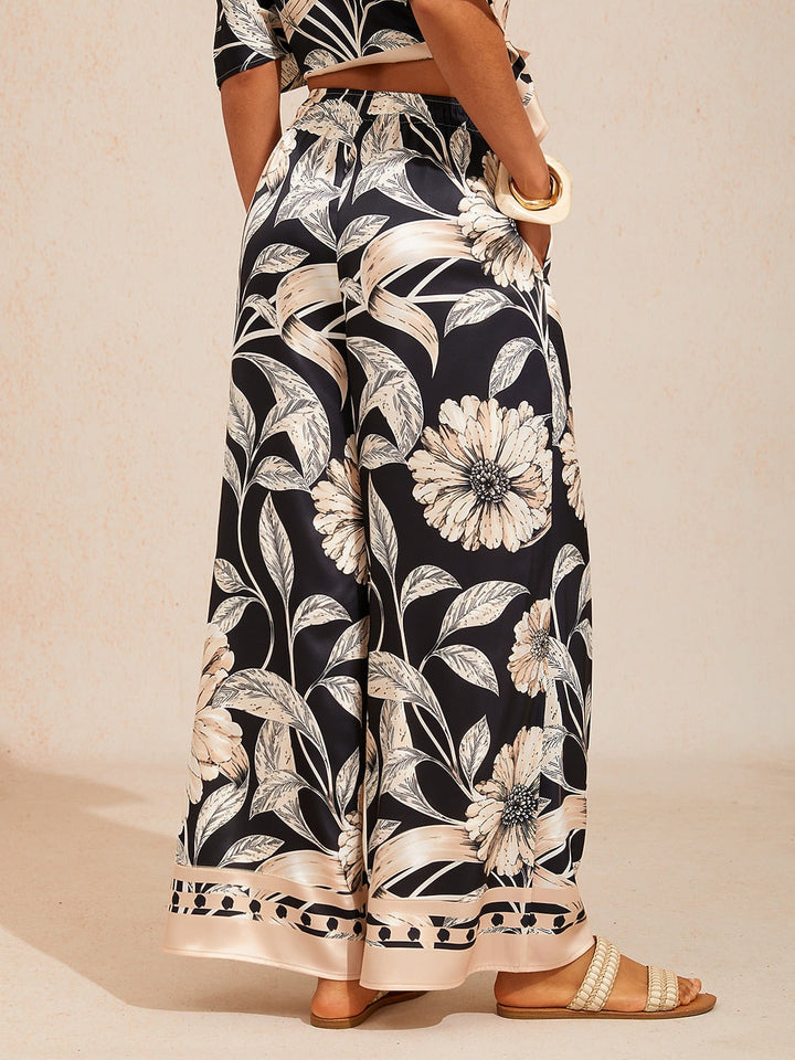 Wide leg pants for women made of silky satin featuring an elastic waist and a floral design in cream and yellow. 5