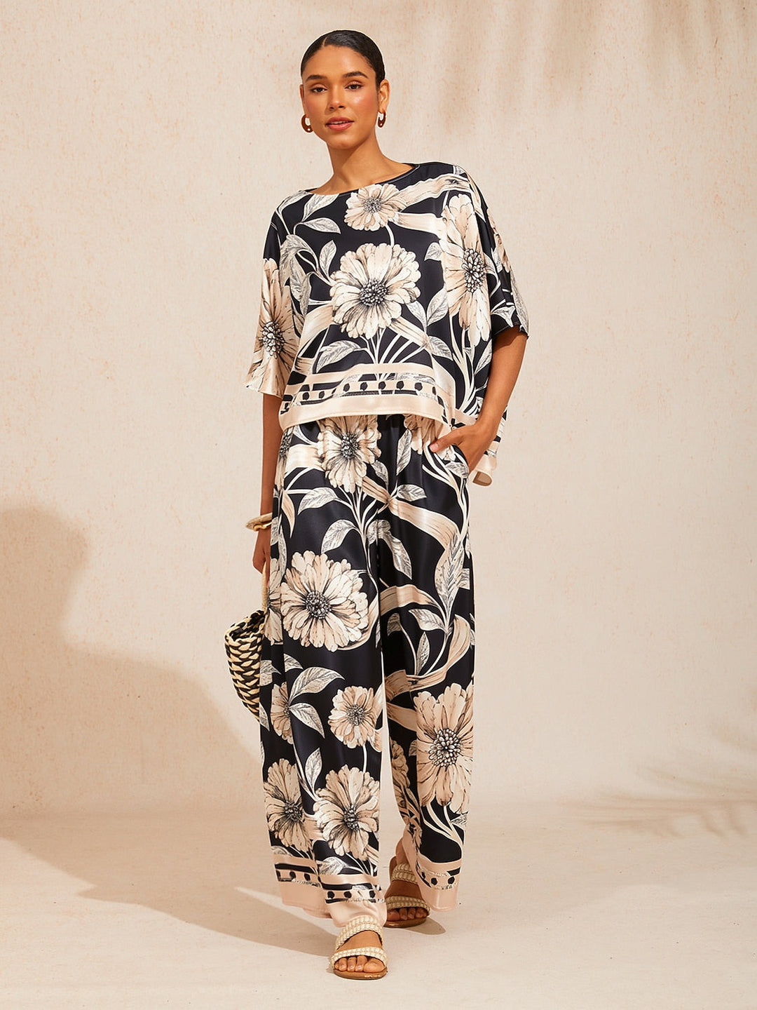 Wide leg pants for women made of silky satin featuring an elastic waist and a floral design in cream and yellow. 8