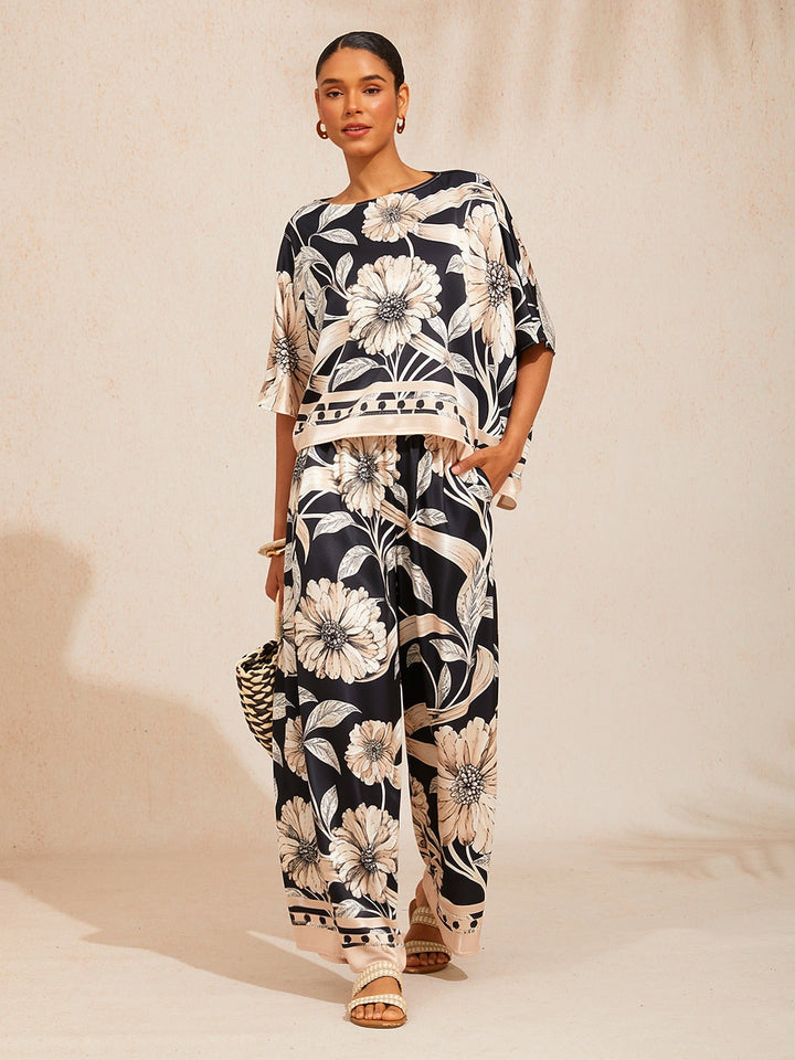 Wide leg pants for women made of silky satin featuring an elastic waist and a floral design in cream and yellow. 8