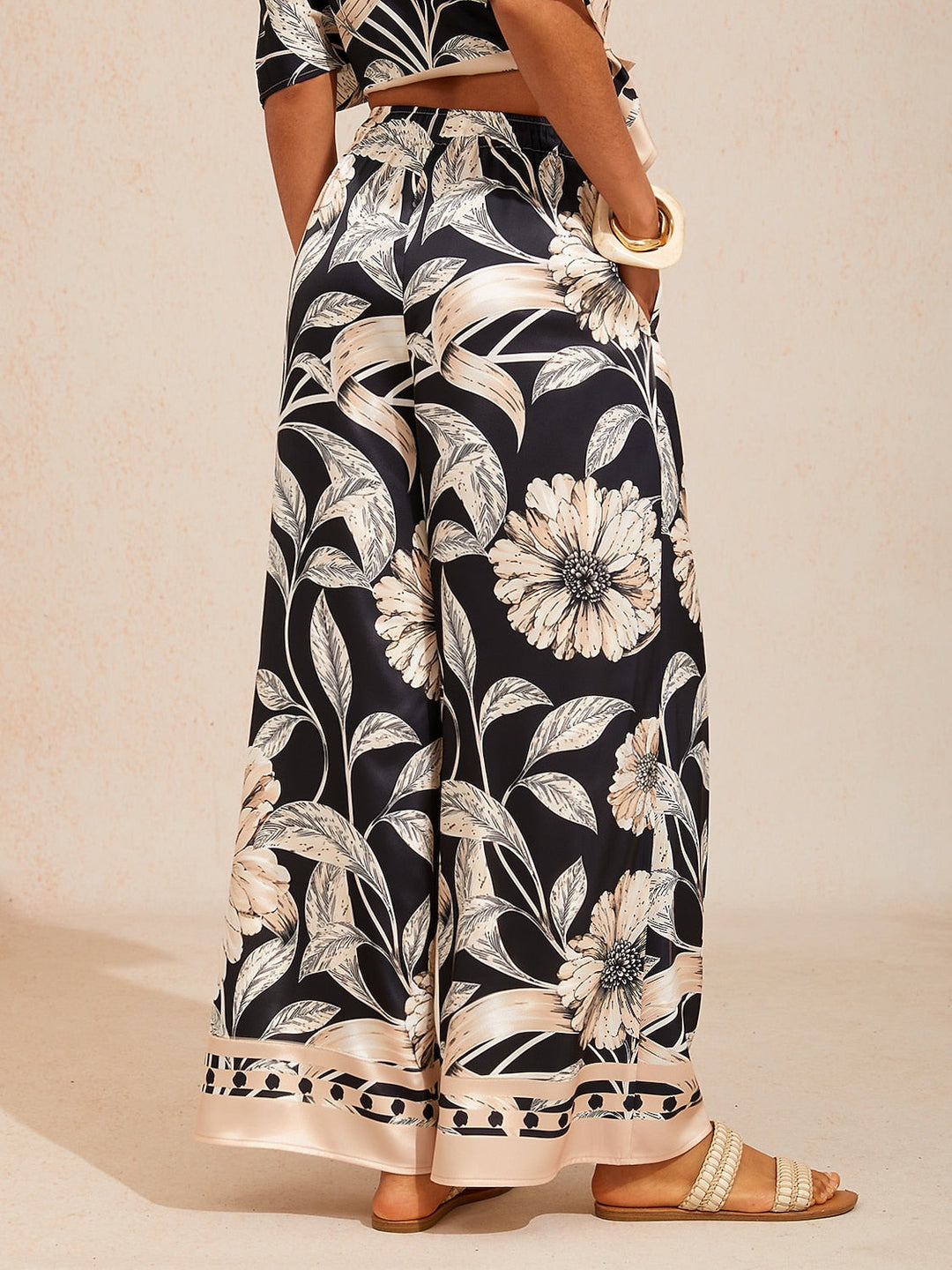 Wide leg pants for women in silky satin featuring an elastic waist and side pockets, adorned with a golden petal print for a flowy and stylish look 1