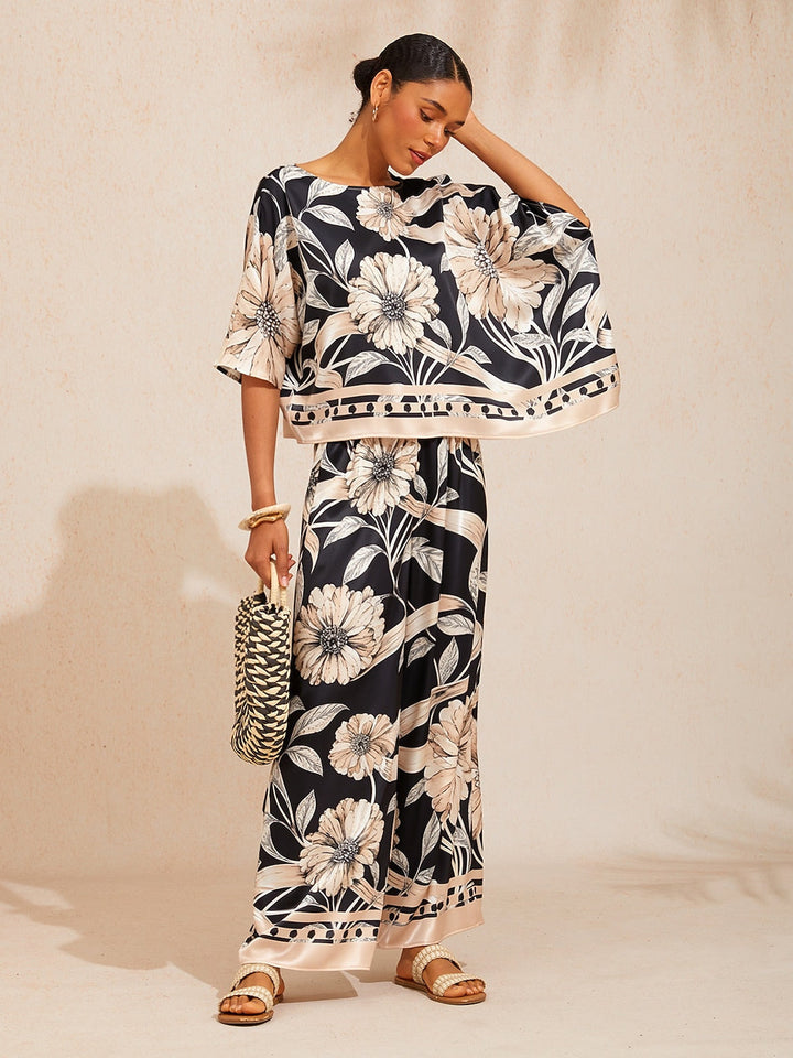 Wide leg pants for women in silky satin featuring an elastic waist and side pockets, adorned with a golden petal print for a flowy and stylish look 2