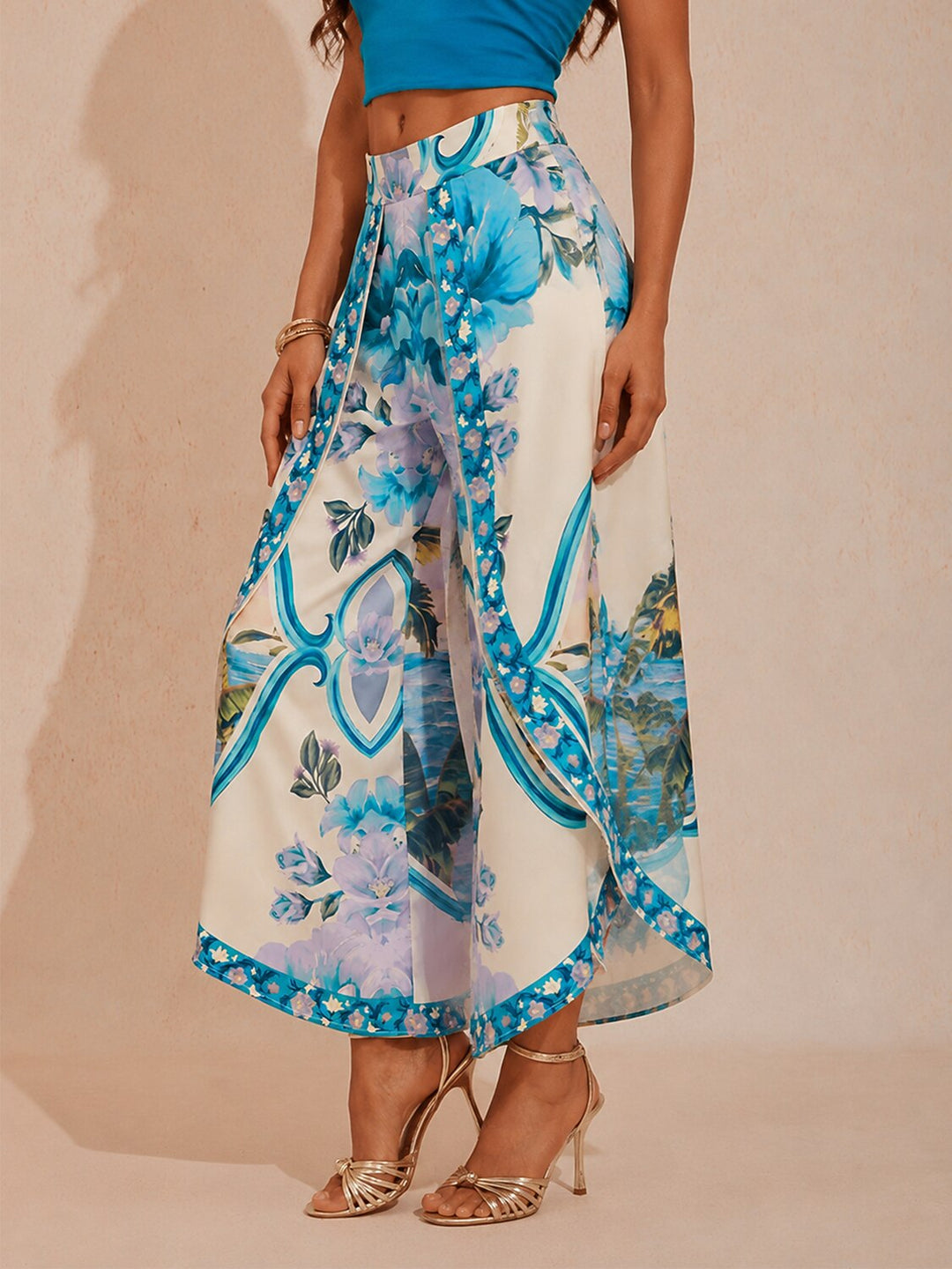 Wide leg pants for women featuring a vibrant tropical palm print, designed in a relaxed fit with luxurious satin fabric, presented in an eye-catching peacock blue 1