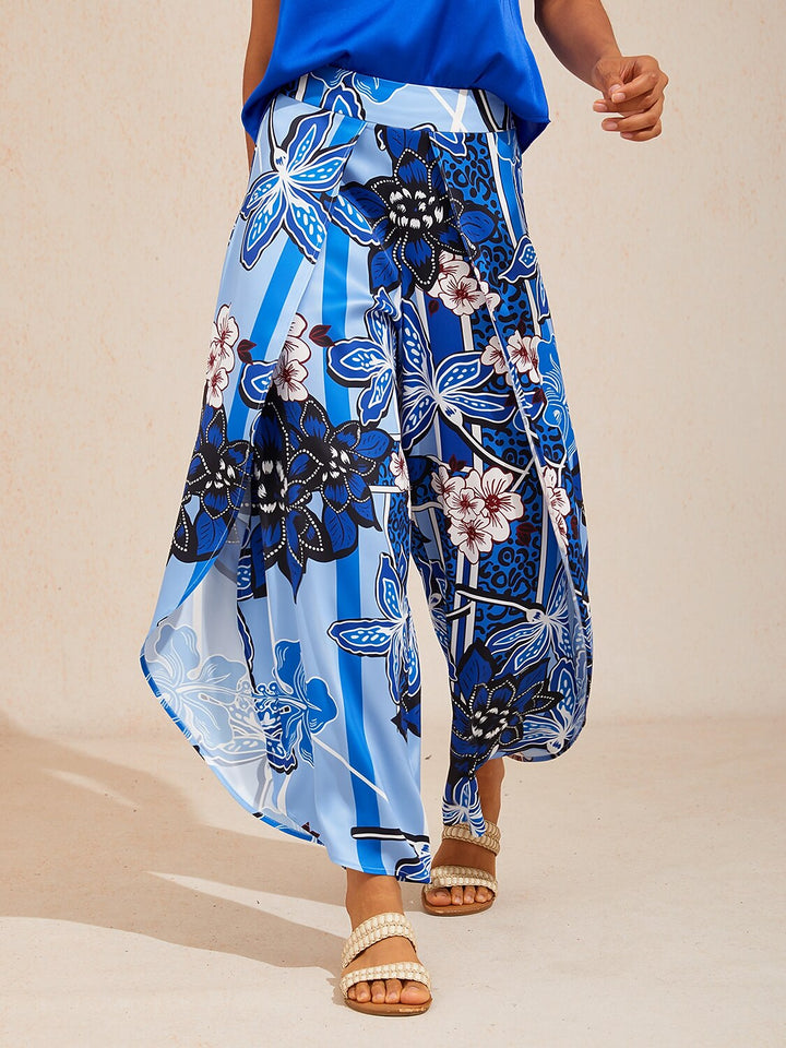 Wide leg pants featuring a high-rise waist in a silky satin fabric with a vibrant tropical floral print, perfect for stylish summer outings. 13