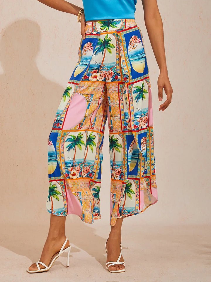 Wide leg pants featuring a high-rise waist in a silky satin fabric with a vibrant tropical floral print, perfect for stylish summer outings. 14