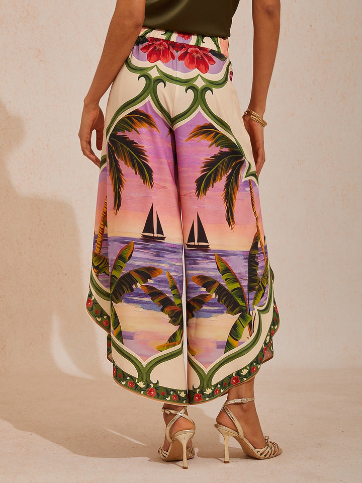 Wide leg pants featuring a high-rise waist in a silky satin fabric with a vibrant tropical floral print, perfect for stylish summer outings. 2