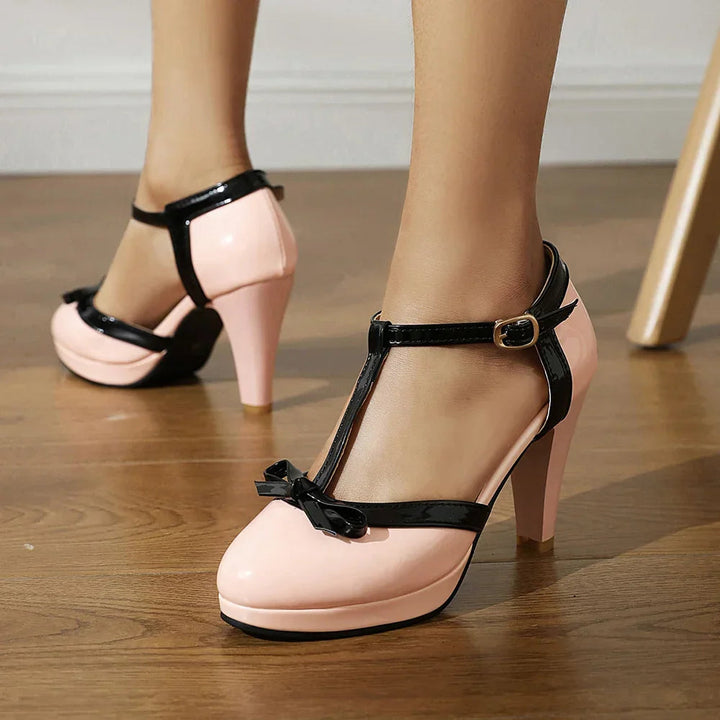 Women's black block heels featuring an adjustable buckle and faux patent leather T-strap design, ideal for stylish and comfortable wear. 2