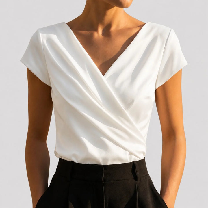 Elegant white women's blouse featuring a draped V-neck and short sleeves, perfect for summer styling.

 0