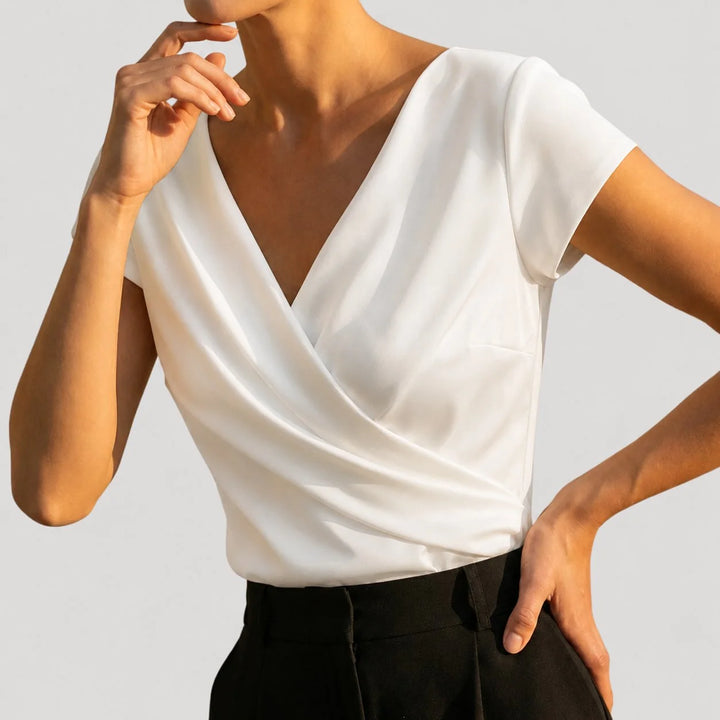 Elegant white women's blouse featuring a draped V-neck and short sleeves, perfect for summer styling.

 1