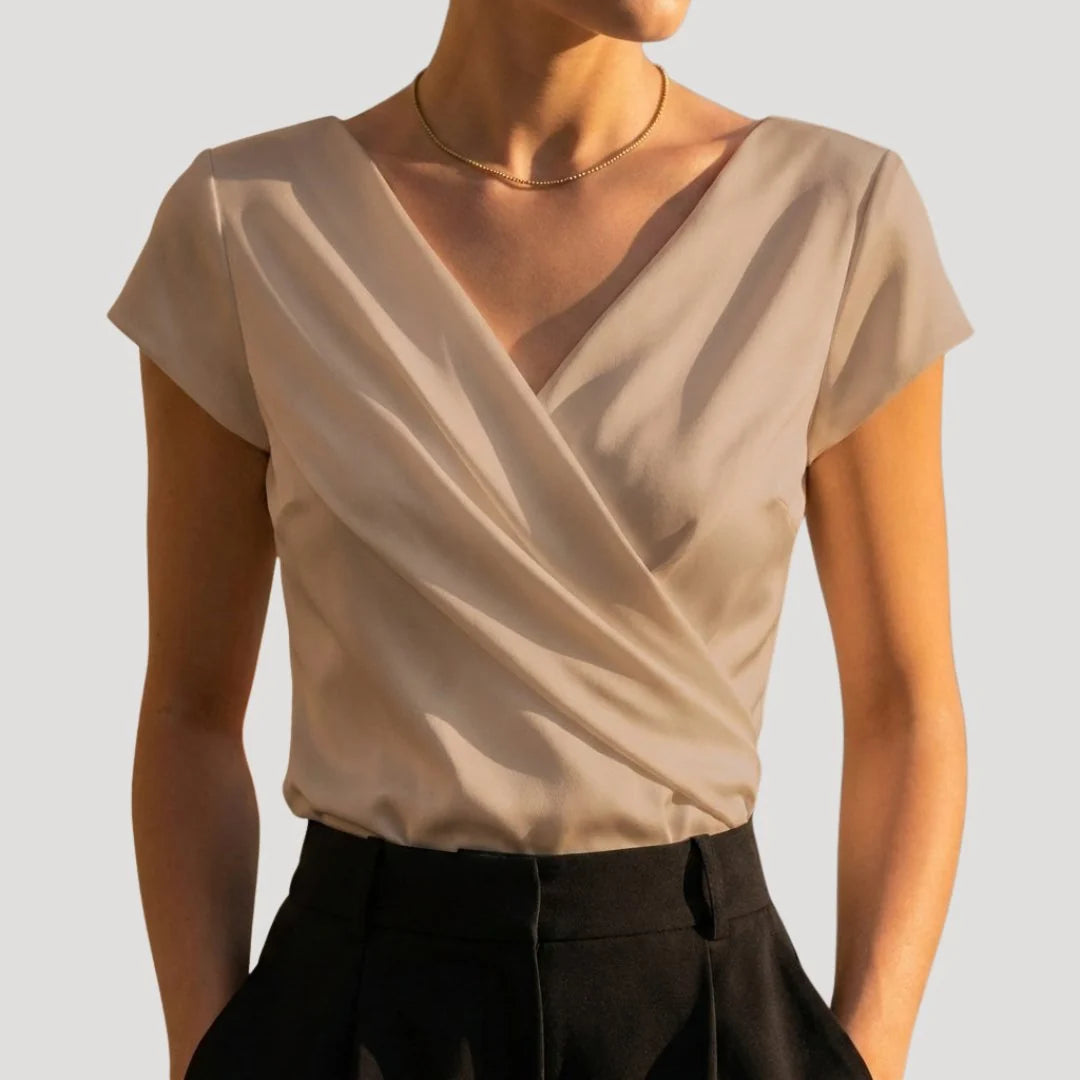 Elegant white women's blouse featuring a draped V-neck and short sleeves, perfect for summer styling.

 2