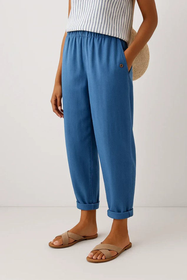 Women's breathable white linen pants featuring an elastic waistband and hidden pockets, perfect for summer wear. 2