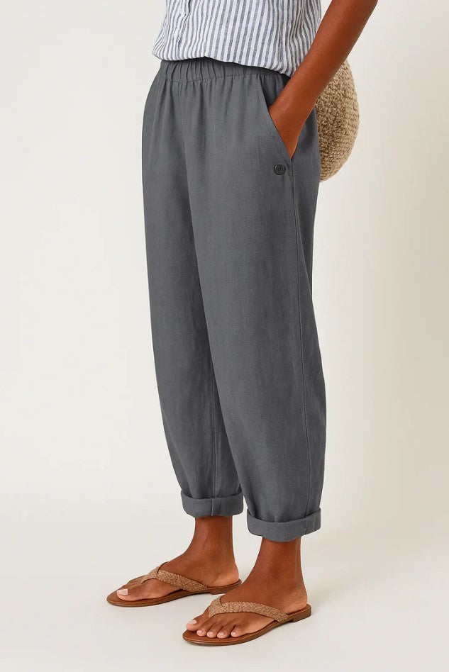 Women's breathable white linen pants featuring an elastic waistband and hidden pockets, perfect for summer wear. 4