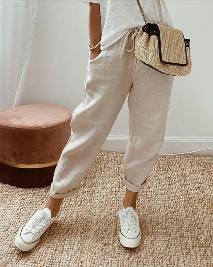 Women's breathable white linen pants featuring a relaxed fit, perfect for casual wear and warm weather styling. 0