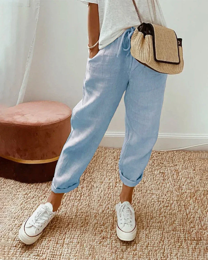 Women's breathable white linen pants featuring a relaxed fit, perfect for casual wear and warm weather styling. 2