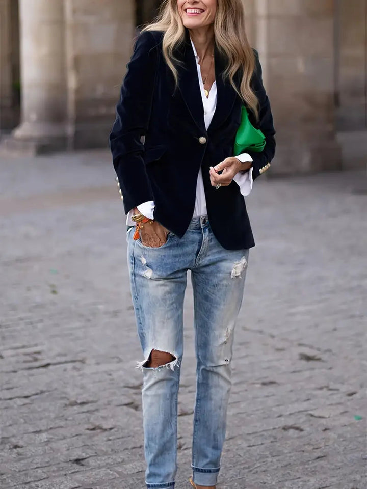 Women's black velvet blazer featuring a tailored design, ideal for versatile styling and elegant occasions. 2