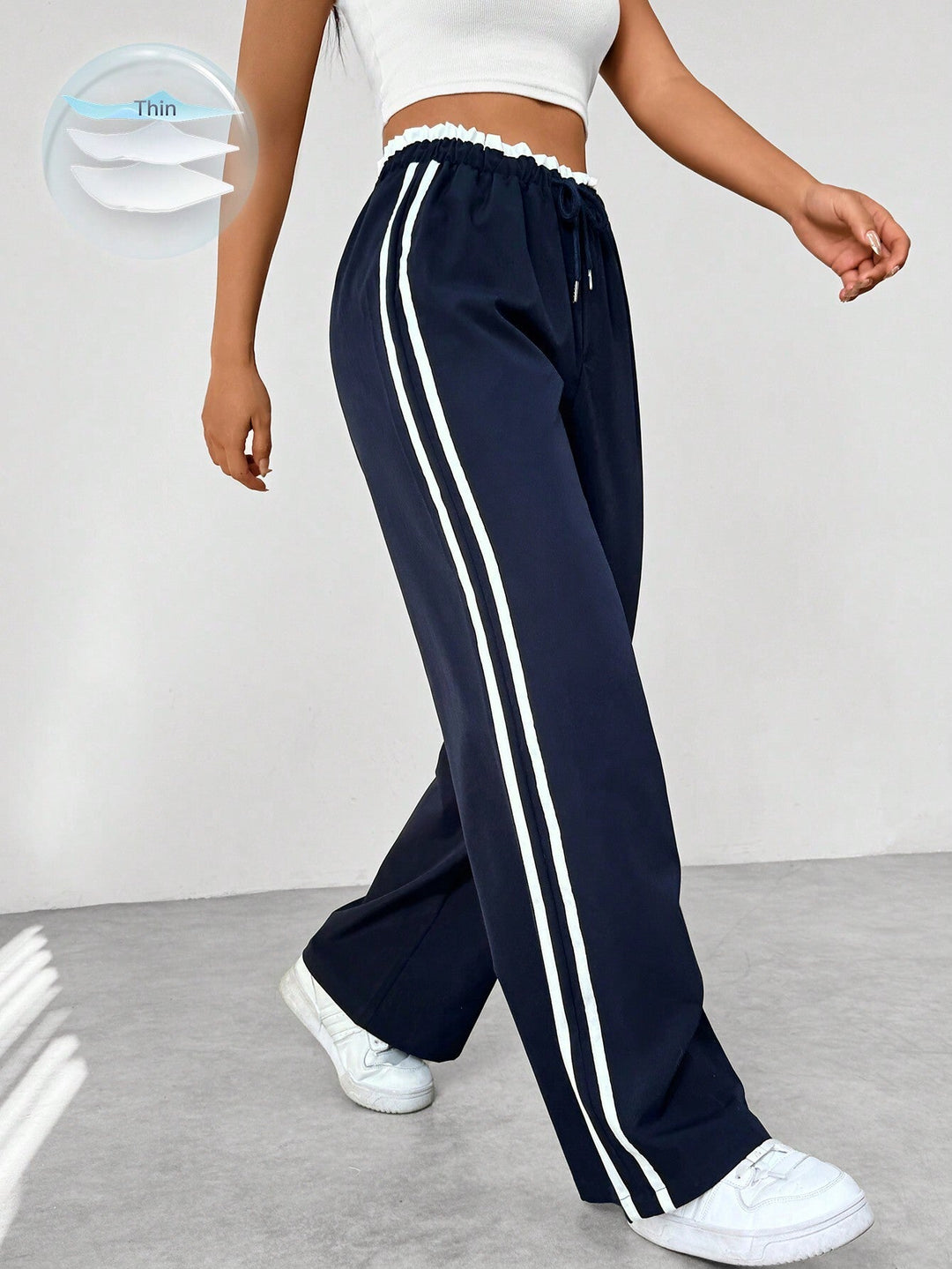 Women's wide leg trousers featuring an adjustable drawstring waist, sporty side stripes, and a lightweight design for a casual and comfortable look. 0