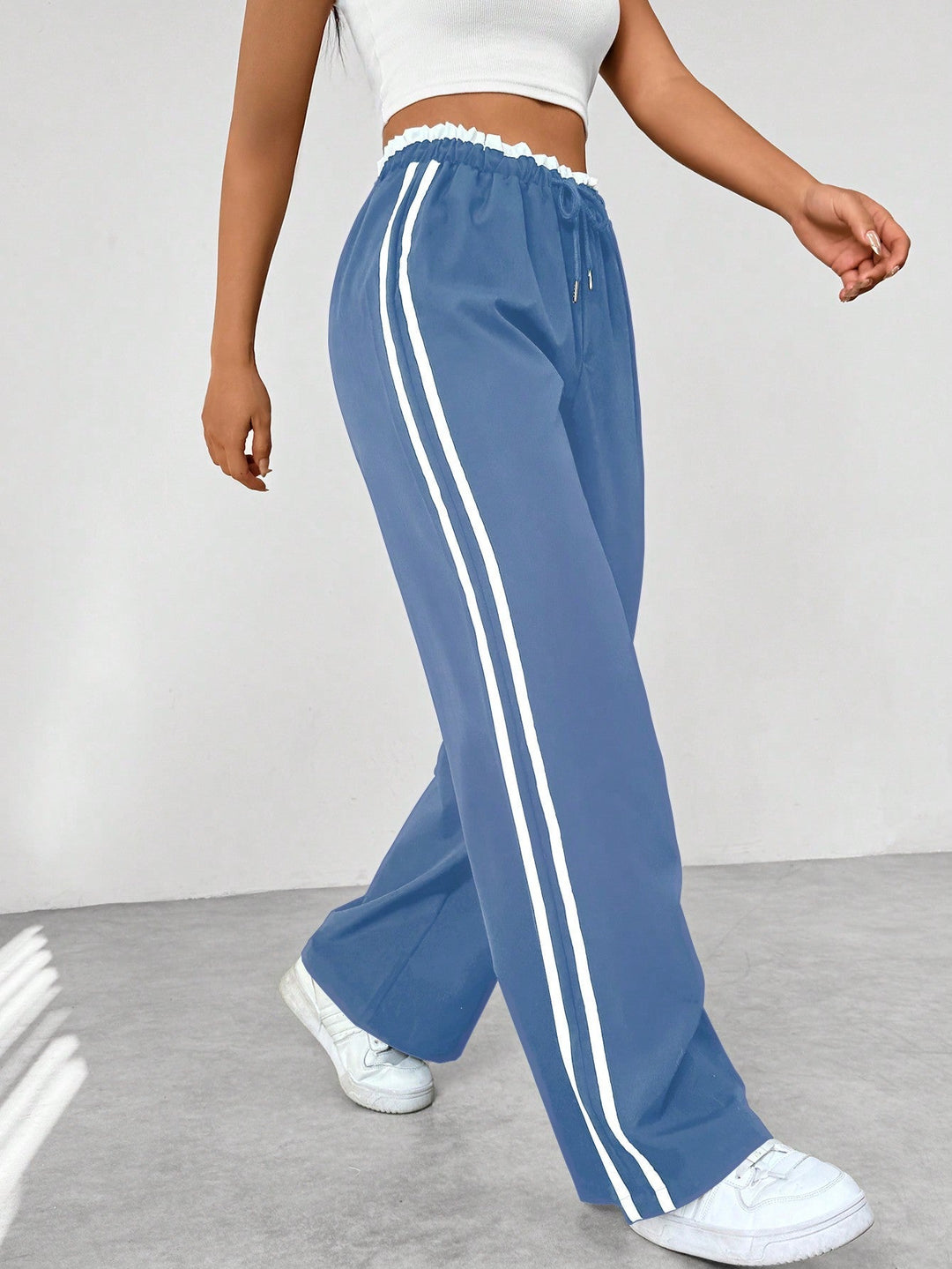 Women's wide leg trousers featuring an adjustable drawstring waist, sporty side stripes, and a lightweight design for a casual and comfortable look. 1