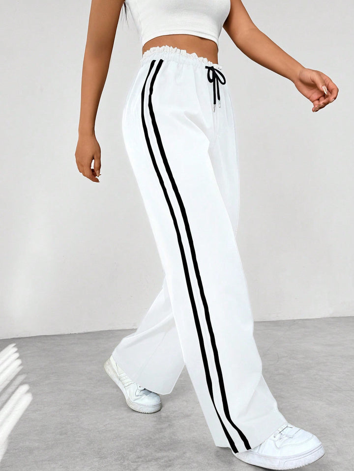 Women's wide leg trousers featuring an adjustable drawstring waist, sporty side stripes, and a lightweight design for a casual and comfortable look. 4