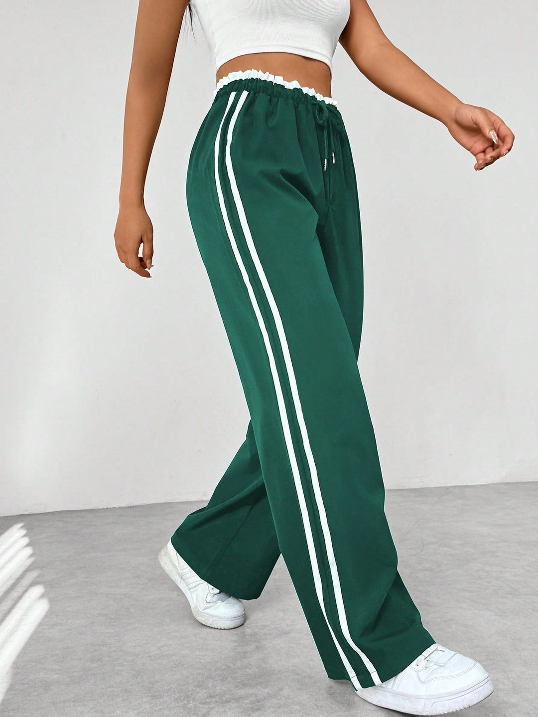 Women's wide leg trousers featuring an adjustable drawstring waist, sporty side stripes, and a lightweight design for a casual and comfortable look. 6