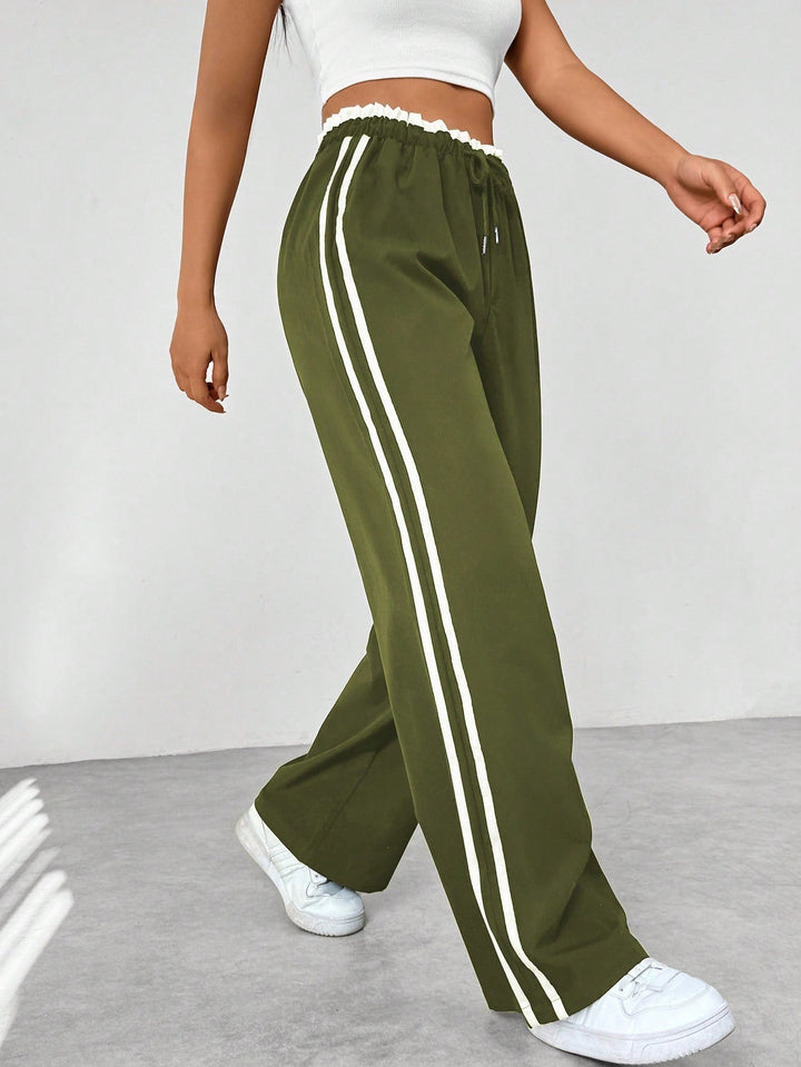 Women's wide leg trousers featuring an adjustable drawstring waist, sporty side stripes, and a lightweight design for a casual and comfortable look. 7